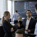 Trois professionnels de la finance, deux hommes et une femme, discutent activement de données boursières affichées sur de grands écrans dans une salle de marché moderne, un visuel illustrant l’expertise nécessaire pour savoir comment choisir sa solution d'investissement pour 2027.