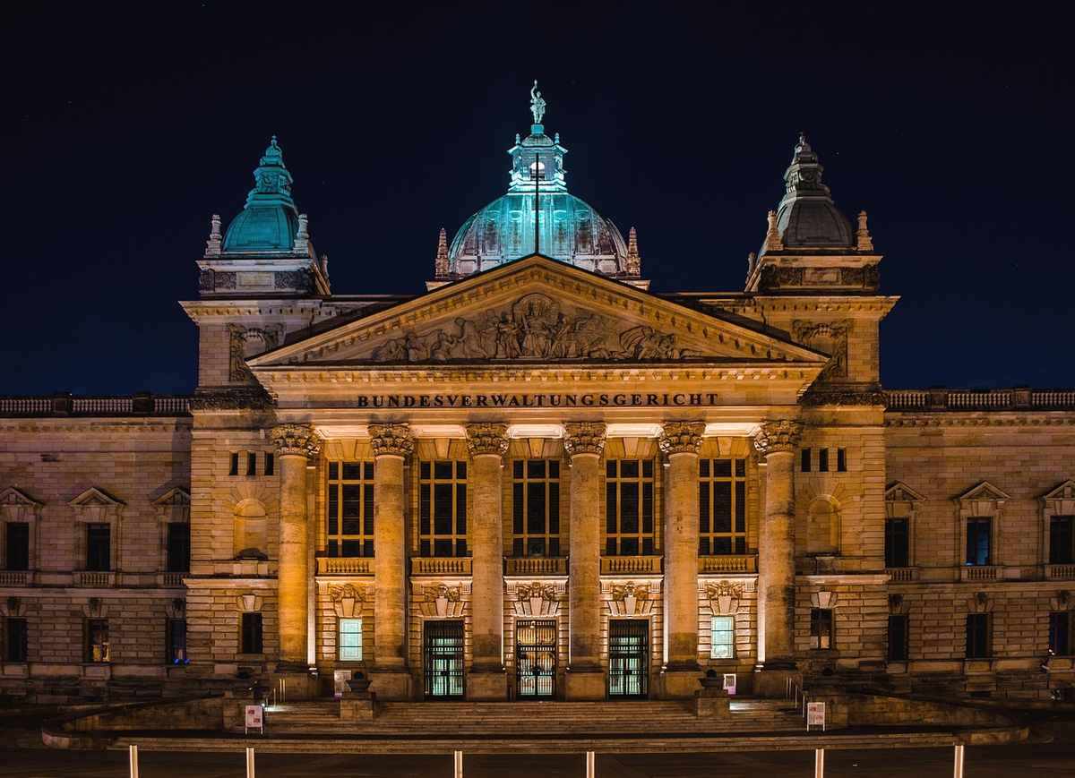 Bâtiment monumental de nuit avec dômes éclairés, colonnes et façade symétrique