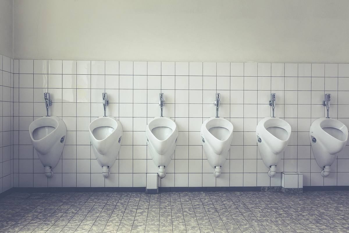 Six urinoirs alignés sur un mur carrelé dans une salle de bain Six urinoirs alignés sur un mur carrelé dans une salle de bain